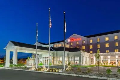 a hotel with two flags in front of a building at Hilton Garden Inn Wayne in Wayne