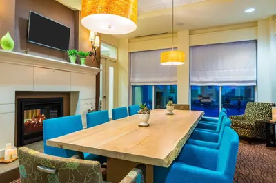 a dining room with a wooden table and blue chairs at Hilton Garden Inn Wayne in Wayne