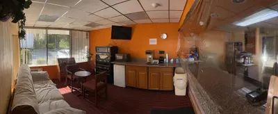 a living room with a couch and a kitchen at Travelers Inn in South Brunswick Terrace