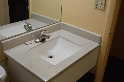 a white sink in a bathroom with a mirror at Travelers Inn in South Brunswick Terrace