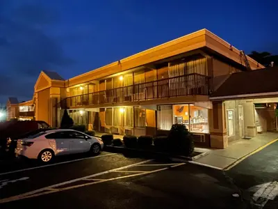 a car parked in front of a building at night at Travelers Inn in South Brunswick Terrace