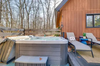 a jacuzzi tub on the back of a house at Private Hot Tub and Game Room Pocono Family Cabin! in Tobyhanna