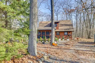a house in the woods with pumpkins in front of it at Private Hot Tub and Game Room Pocono Family Cabin! in Tobyhanna