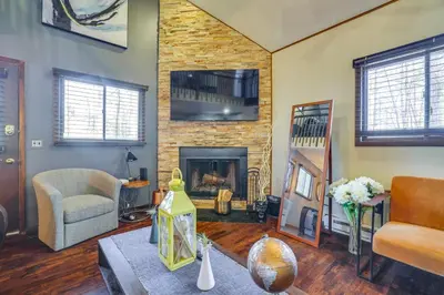 a living room with a couch and a fireplace at Private Hot Tub and Game Room Pocono Family Cabin! in Tobyhanna