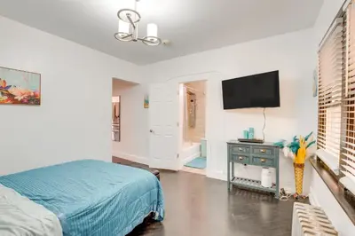 a bedroom with a bed and a flat screen tv at 1 Mi to Train Station Quiet Apartment in Newark in Newark