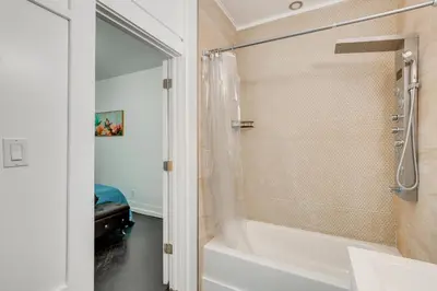 a bathroom with a shower and a white tub at 1 Mi to Train Station Quiet Apartment in Newark in Newark