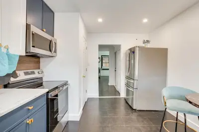 a kitchen with blue cabinets and a stainless steel refrigerator at 1 Mi to Train Station Quiet Apartment in Newark in Newark