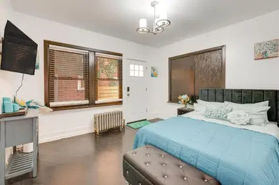 a bedroom with a blue bed and a television at 1 Mi to Train Station Quiet Apartment in Newark in Newark