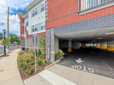 a parking lot in front of a building with a stop sign at 327 Modern 1BR Apt Walk to NJT in Dunellen