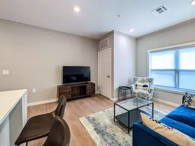 a living room with a blue couch and a tv at 328 Modern 2BR Apt in Dunellen