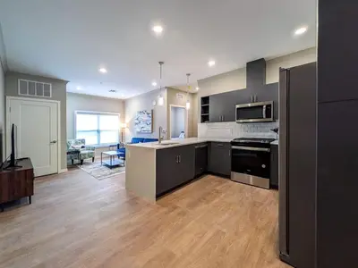 a large kitchen with black appliances and a living room at 328 Modern 2BR Apt in Dunellen