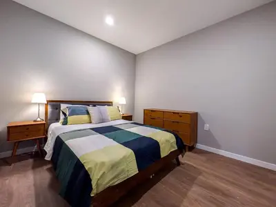 a bedroom with a bed and a dresser and lamp at 328 Modern 2BR Apt in Dunellen