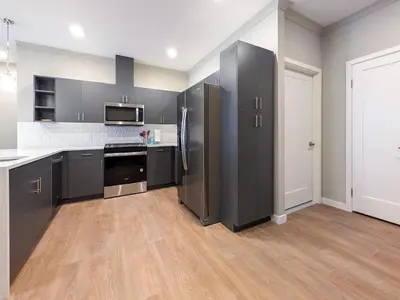 a large kitchen with stainless steel appliances and wood floors at 328 Modern 2BR Apt in Dunellen