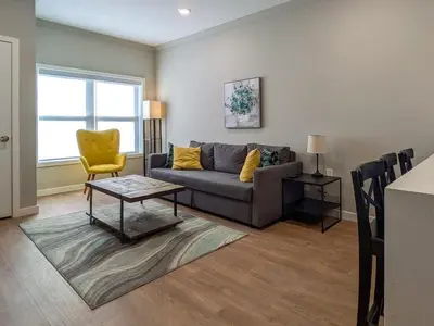a living room with a couch and a yellow chair at 221 Modern 1BR Apt Walk to NJT in Dunellen
