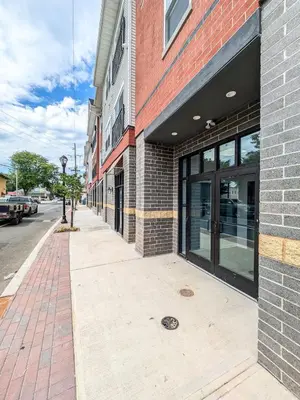 an empty sidewalk in front of a brick building at 212 Modern 1BR Apt Walk to NJTransit in Dunellen