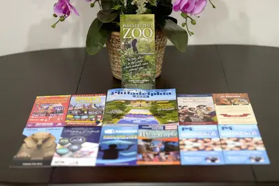 a table topped with books and a vase with flowers at Spacious and Brand New Apartment in Point Breeze - Prime Location in Philadelphia