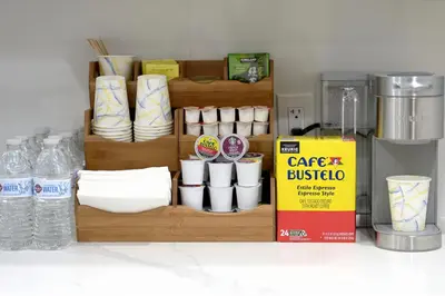 a shelf with cups and plates and water bottles at Spacious and Brand New Apartment in Point Breeze - Prime Location in Philadelphia
