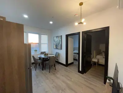 a living room with a table and a dining room at Apartment Few Minutes NYC and Prudential Center in Newark