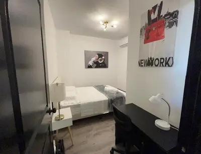a small bedroom with a bed and a mirror at Apartment Few Minutes NYC and Prudential Center in Newark