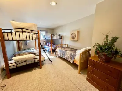 a bedroom with two bunk beds and a dresser at Lake Harmony 4bdrm Ski pool hot tub lake in Lake Harmony
