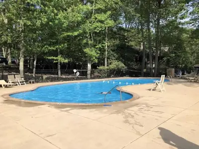 a large swimming pool with blue water in a park at Lake Harmony 4bdrm Ski pool hot tub lake in Lake Harmony