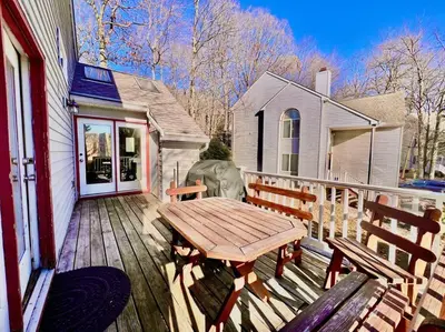 a wooden deck with a wooden table and benches at Lake Harmony 4bdrm Ski pool hot tub lake in Lake Harmony