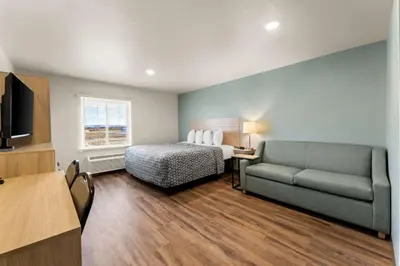 a hotel room with a bed and a couch at WoodSpring Suites Easton Nazareth in Easton