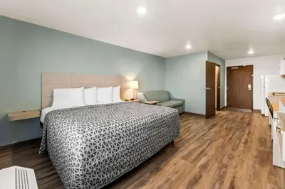 a hotel room with a bed and a chair at WoodSpring Suites Easton Nazareth in Easton