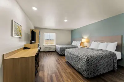 a hotel room with two beds and a flat screen tv at WoodSpring Suites Easton Nazareth in Easton