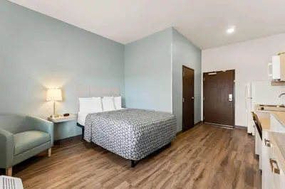 a bedroom with a bed and a couch in a room at WoodSpring Suites Easton Nazareth in Easton