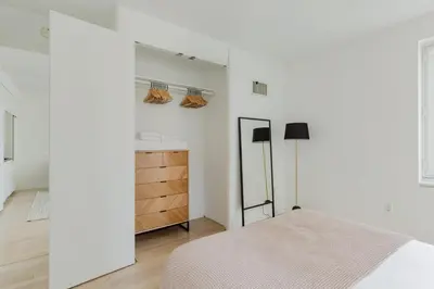 a white bedroom with a bed and a closet at Blueground Midtown gym wd ac nr Rock Ctr NYC-1536 in New York