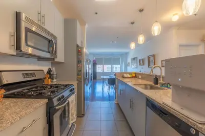 a kitchen with a stove and a sink at King Master and Plush Queen near NYC w kitchen, living room plus on-site gym in Jersey City