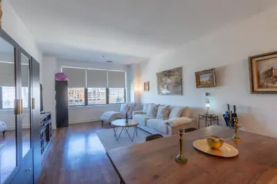 a living room with a table and a couch at King Master and Plush Queen near NYC w kitchen, living room plus on-site gym in Jersey City