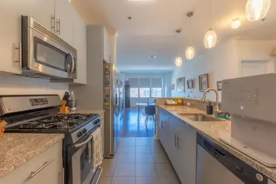 a kitchen with a stove and a sink at King Master and Plush Queen near NYC w kitchen, living room plus on-site gym in Jersey City