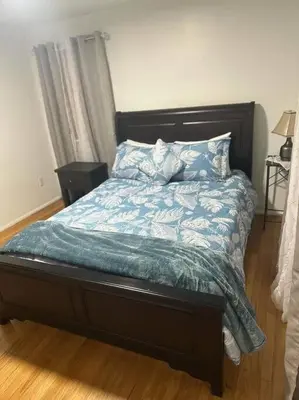 a bed with a blue comforter and pillows on it at Cozy 3BR Home near Downtown Lancaster in Lancaster