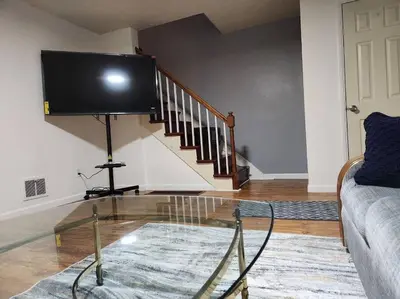 a living room with a glass table and a tv at Cozy 3BR Home near Downtown Lancaster in Lancaster