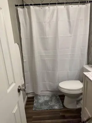 a bathroom with a toilet and a shower curtain at Perfect Lehigh Valley Oasis in Bethlehem