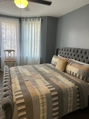 a bedroom with a large bed with a blanket at Genevieves lovely suite in Jersey City