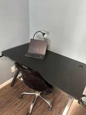 a laptop computer sitting on top of a black desk at Genevieves lovely suite in Jersey City
