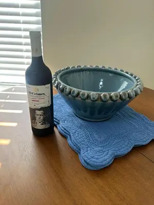 a bottle of wine next to a bowl on a table at Genevieves lovely suite in Jersey City