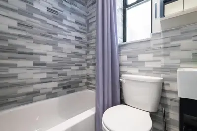 a bathroom with a toilet and a bath tub at 4 Bedroom Paradise next to Central Park in New York