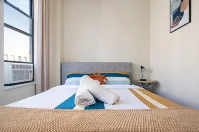 a bedroom with a bed with towels and a window at 4 Bedroom Paradise next to Central Park in New York