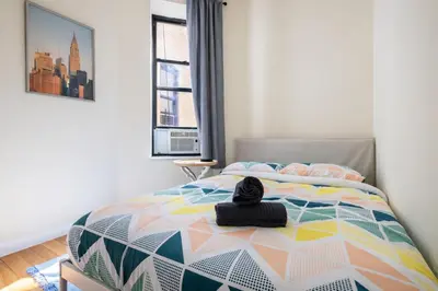 a bedroom with a bed with a hat on it at 4 Bedroom Paradise next to Central Park in New York