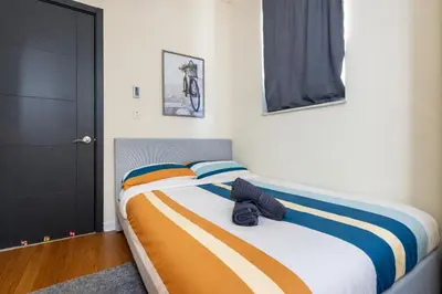 a bedroom with a bed with an orange and blue blanket at 4 Bedroom Paradise next to Central Park in New York