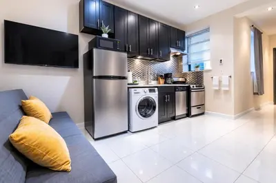 a kitchen with a couch and a washer and dryer at 4 Bedroom Paradise next to Central Park in New York