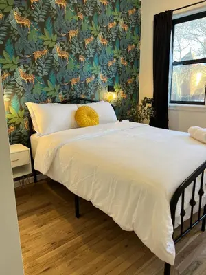 a bedroom with a large bed with a floral wallpaper at Luxury Boutique Home - 5 Beds 2 Baths 25 minutes to NYC in Jersey City