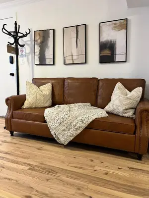 a brown leather couch sitting in a living room at Luxury Boutique Home - 5 Beds 2 Baths 25 minutes to NYC in Jersey City