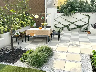 a garden with a table and chairs on a patio at Designer cozy 1 private bedroom w full bath & yard 20 min to nyc in Harrison