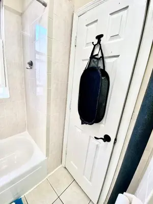 a bag hanging on a door in a bathroom at Apart Studio West NYNJ 12Mints From NYCity TimeSquare in West New York