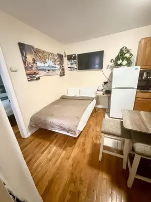 a bedroom with a bed and a wooden floor at Apart Studio West NYNJ 12Mints From NYCity TimeSquare in West New York